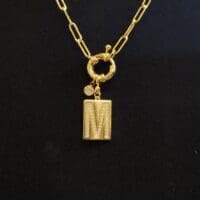 Gold chain necklace with initial M pendant.