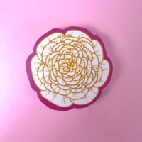 Gold flower sticker on pink background.
